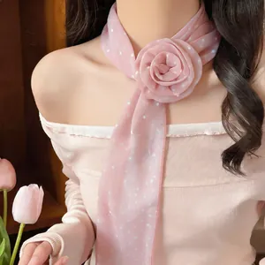 Close-up of pink polka-dot floral scarf accessory worn as a neck scarf.