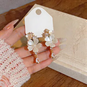 Detail view of elegant gold-plated flower earrings with shimmering zirconia drops