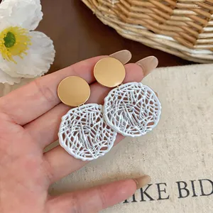 Detailed view of elegant gold and white hollow lattice round drop earrings for women