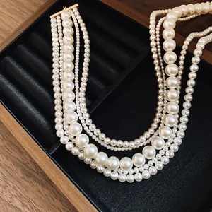 Detailed view of elegant multi-strand white pearl necklace in a wooden jewelry box
