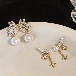 Detail showing elegant gold plated zircon star and pearl earrings displayed on a plate