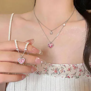 Detailed shot of a pink heart pendant necklace featuring sparkling zircons and a star.