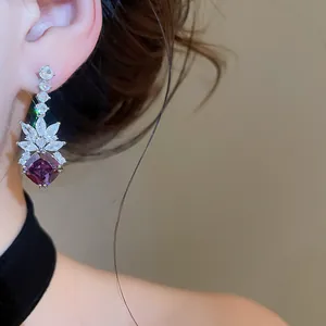 Close-up of luxury purple zircon rhombus drop earrings with floral sparkle details