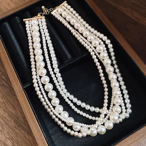 Elegant detail of a multi-strand French style faux pearl necklace displayed on black velvet