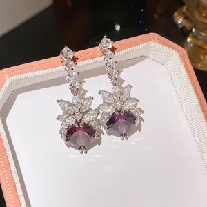 Detailed view of sparkly purple zircon drop earrings in a pink jewelry box