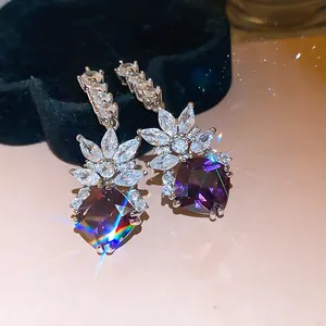 Detailed macro shot of elegant zircon earrings with purple gemstones and sparkling accents.