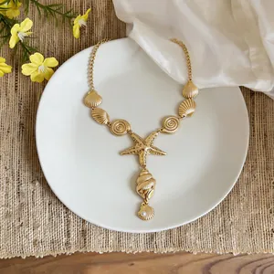 Detailed view of the golden starfish and shell necklace with elegant pearl accent.