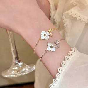 Close-up of elegant flower charm bracelets with shell petals on a woman's wrist