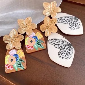 Elegant metal flower stud earrings with floral and butterfly wing acetate pendants
