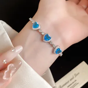 Gros plan d'un élégant bracelet avec des cœurs en zircon bleu sur un poignet de femme
