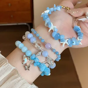 Gros plan détaillé sur des bracelets superposés en perles d'aigue-marine et breloque