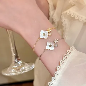 Elegant flower bracelets featuring mother of pearl petals and sparkly crystal accents on wrist.