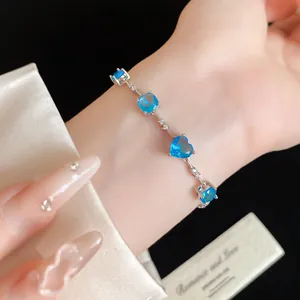 Gros plan d'un élégant bracelet en argent avec des zircons bleus en forme de cœur