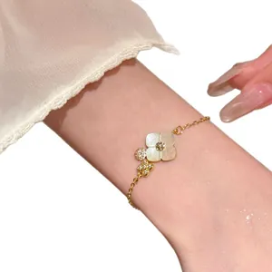 Elegant gold-tone flower bracelet featuring mother of pearl petals and crystal accents