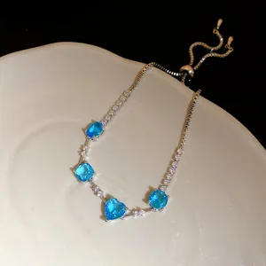 Gros plan d'un bracelet vintage en argent avec zircons bleus en cœur et géométrie