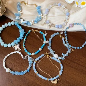 Détail de plusieurs bracelets en aigue-marine avec des breloques papillon et cœur.
