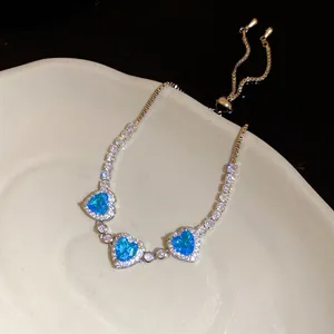 Détail d'un bracelet en argent avec zircons bleus en forme de cœur et fermoir réglable