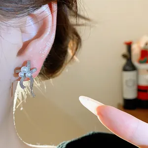 Detailed macro shot of an elegant silver bow-knot pearl earring with shimmering accents