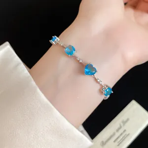 Vue détaillée d'un bracelet élégant en argent avec des zircons bleus en forme de cœur.