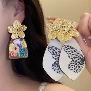Detailed macro view of ethnic retro acetate drop earrings with golden flower studs.