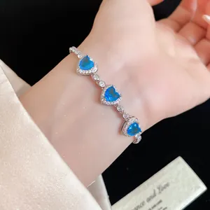 Vue détaillée d'un élégant bracelet argenté avec trois zircons bleus en forme de cœur