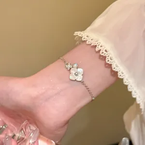 Close-up of elegant flower charm bracelet with mother-of-pearl effect on wrist