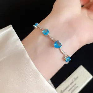 Vue rapprochée d'un bracelet en argent orné de zircons bleus en forme de cœur au poignet