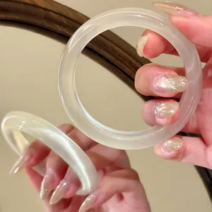 Close-up of translucent cat-eye stone bangle showing reflective luster and texture