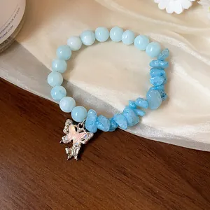 Détail rapproché d'un bracelet en aigue-marine bleu clair au pendentif papillon