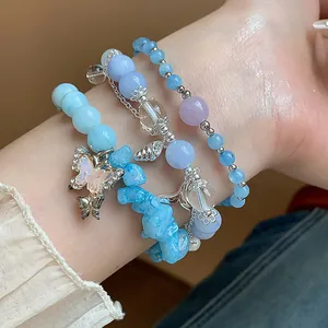 Détail d'un ensemble de bracelets en aigue-marine avec pendentif papillon délicat