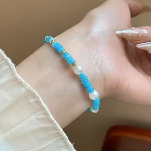 Détail d'un bracelet en perles d'aigue-marine bleue et de perles blanches de style coréen au poignet