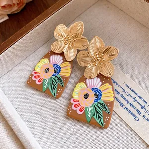 Macro detail of vintage gold flower earrings featuring colorful floral acetate drop pendants