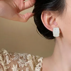 Close-up view of elegant rectangular pearl stud earrings with a French vintage style.