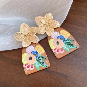 Close-up of vintage acetate floral drop earrings featuring metallic gold flower studs.