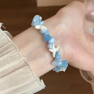 Gros plan détaillé d'un bracelet en aigue-marine irrégulière avec étoiles de mer au poignet