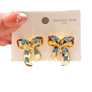 Elegant gold-toned stainless steel bow stud earrings with blue floral bead accents