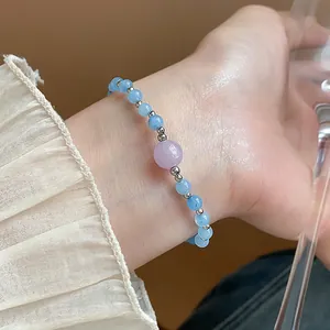 Gros plan détaillé d'un bracelet en perles d'aigue-marine avec pierre centrale mauve
