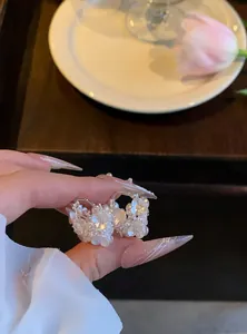 Vue détaillée de boucles d'oreilles fleurs blanches de style français avec perles