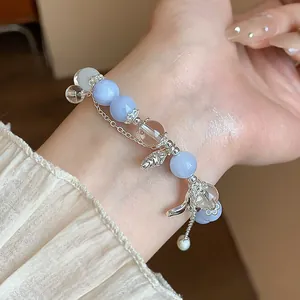 Vue détaillée d'un élégant bracelet en perles d'aigue-marine avec breloques argentées