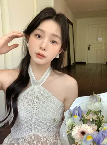 Détail d'élégantes boucles d'oreilles créoles fleurs blanches et perles sur mannequin