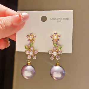 Detail view of elegant vintage flower drop earrings with purple zirconia and pearls