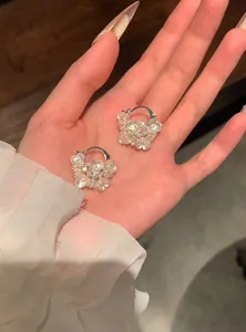 Vue détaillée de boucles d'oreilles créoles fleurs de style français avec perles et strass