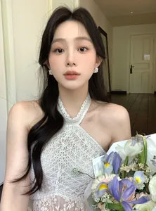 Gros plan sur d'élégantes boucles d'oreilles fleurs blanches portées par un mannequin