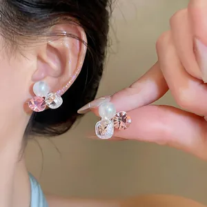Detailed close-up view of the sparkling pink crystal and pearl cluster ear clip on ear.