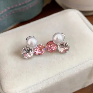 Detail view of elegant clip-on earrings featuring a white pearl and pink crystals