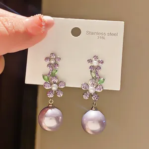 Detailed view of lavender purple pearl drop earrings with purple flower zircon accents.