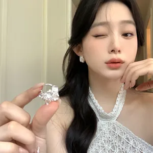 Vue détaillée d'une créole en argent avec fleurs en diamant sur mannequin.