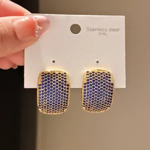 Macro view of vintage gold earrings featuring micropave blue zircons on 316L card