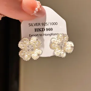 Detailed macro shot of elegant vintage flower stud earrings with pearls and zircons
