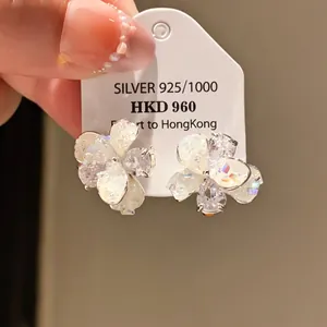 Close-up detail of vintage-style silver flower earrings featuring sparkling zircon stones